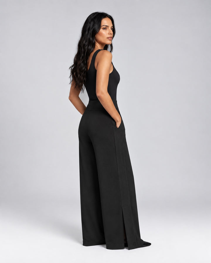 Side view of the Liberty black matte jersey pants on a model, showing the hidden pocket, side panel and overlapping ankle vent.
