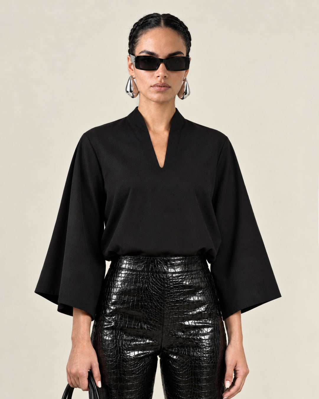 Front view of the black Waverly top showing its butterfly sleeves and split neckline.