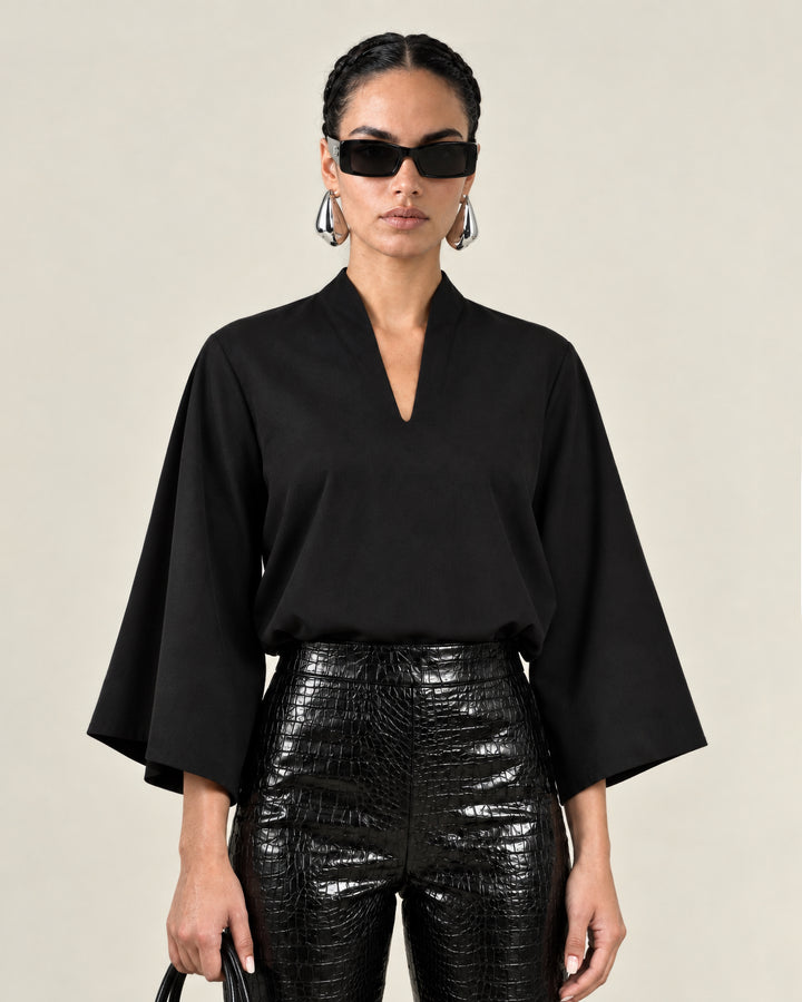 Front view of the black Waverly top showing its butterfly sleeves and split neckline.