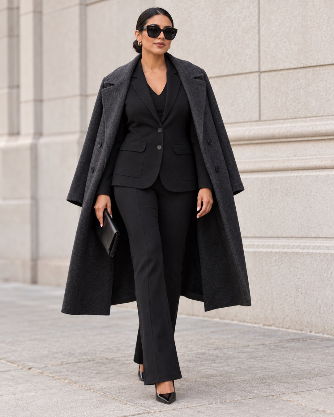 Greenwich black blazer and Essex pants styled under an oversized charcoal coat with sunglasses and a sleek black clutch